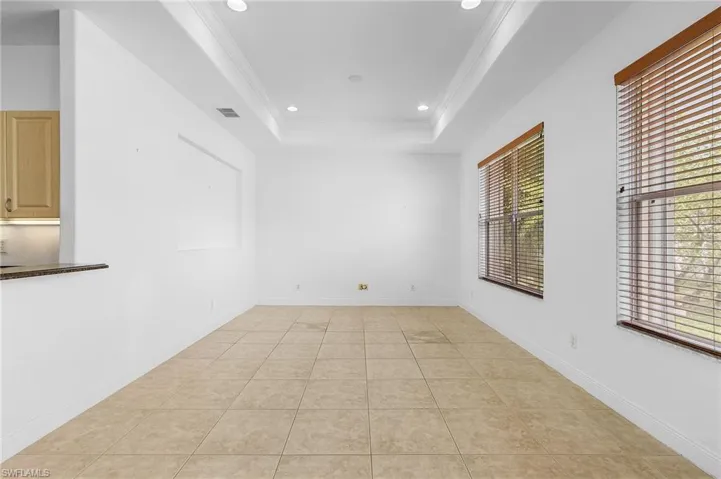 Family room featuring a tray ceiling, plenty of natural light, and ornamental molding