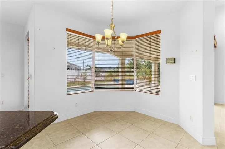 Unfurnished breakfast nook area with a notable chandelier and light tile patterned flooring