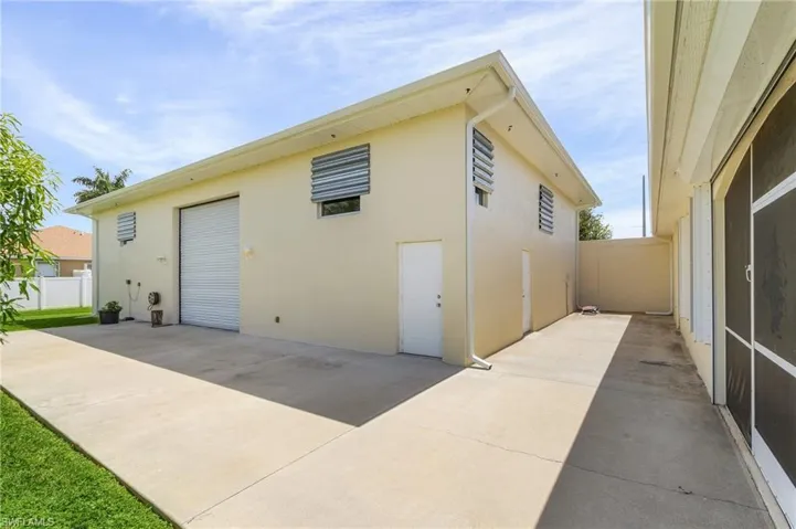 Rear view of detached garage featuring a back rolling door.