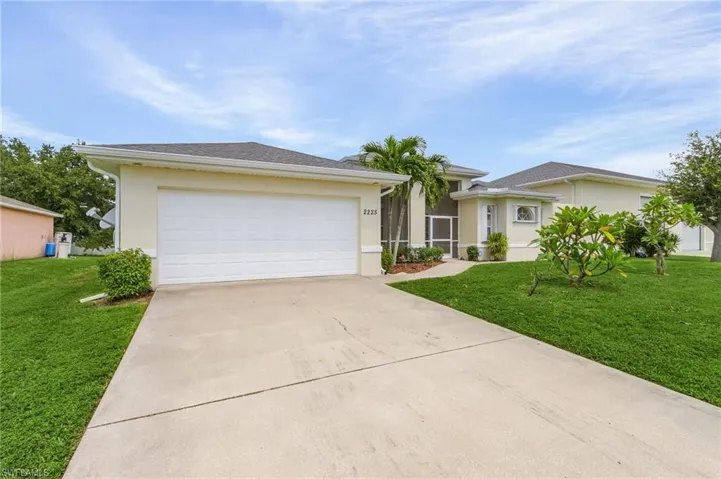 View of front of property with a garage and a front lawn