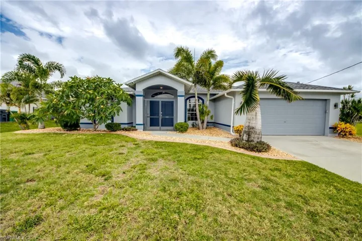 Ranch-style home with stucco siding, an attached garage, driveway, and a front yard