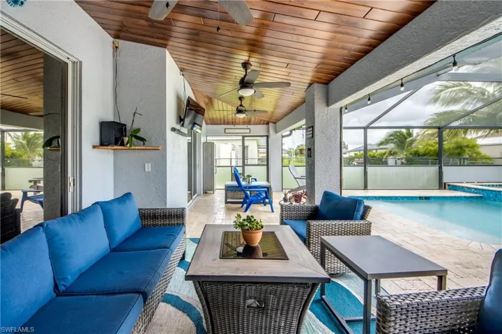Sunroom / solarium featuring ceiling fan, an outdoor hangout area, a swimming pool, and lofted ceiling