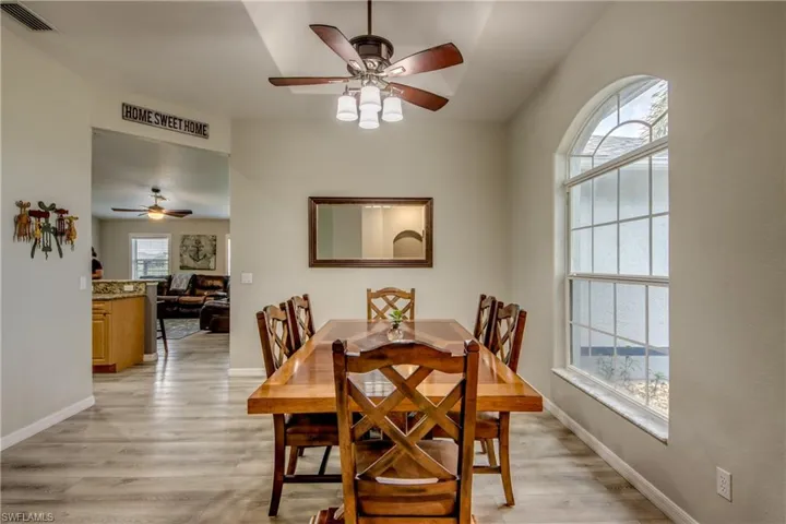 Dining area with a ceiling fan and light wood-style floors