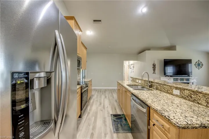 Kitchen with stainless steel appliances, light wood-type flooring, and light brown cabinetry