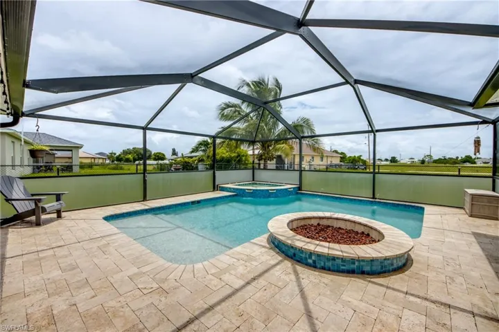 View of pool with a patio, a pool with connected hot tub, and glass enclosure
