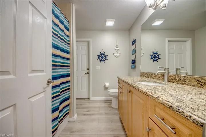 Full bath with vanity, wood finished floors, and a shower with shower curtain