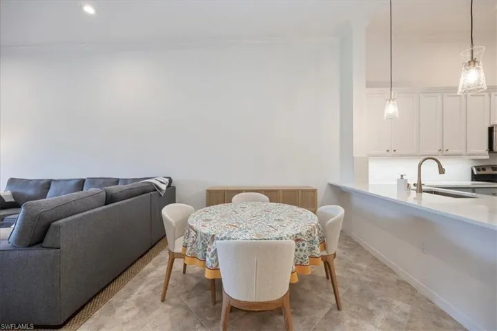 Dining space with ornamental molding and recessed lighting