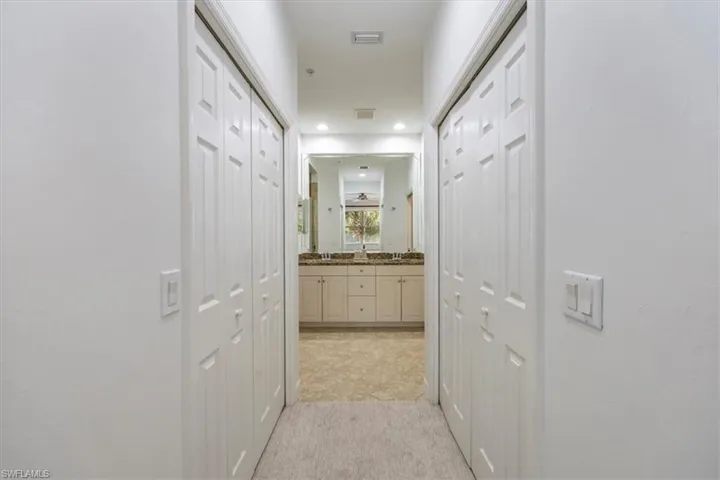 Corridor featuring recessed lighting and dual closets