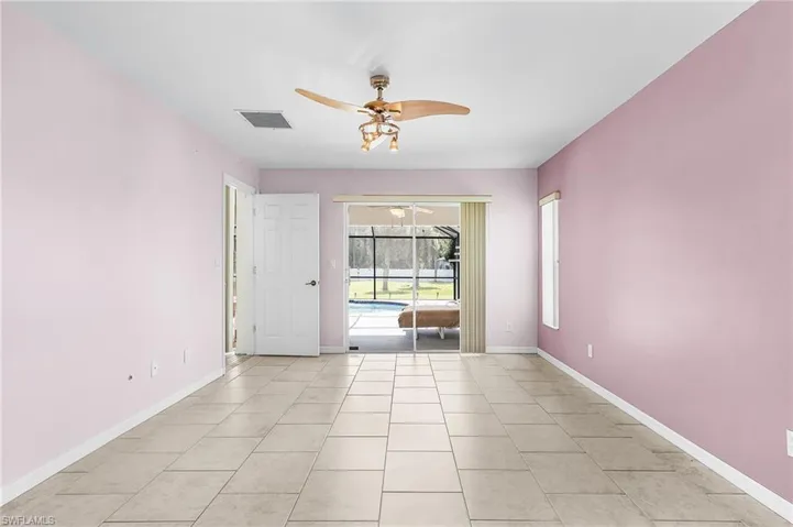 Spare room featuring a sunroom, light tile patterned floors, and ceiling fan