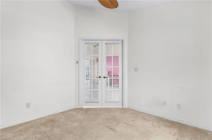 Spare room with carpet, french doors, and a ceiling fan