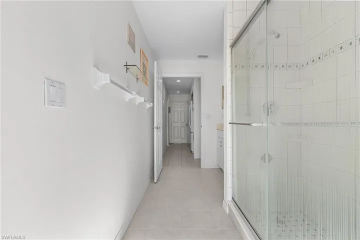 Corridor with light tile patterned floors and baseboards