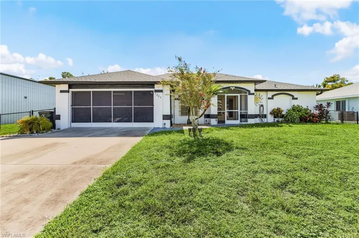 Ranch-style home featuring concrete driveway, stucco siding, a sunroom, and a shingled roof