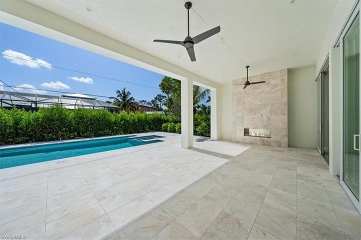 The pool deck features marble pavers, natural gas fireplace, outdoor kitchen, covered and uncovered areas, and pool with flush spa. Greenery has been planted along the rear and side property fence and will mature over the next several months. The openings have been pre-wired for optional roll-down bug and/or storm screens.