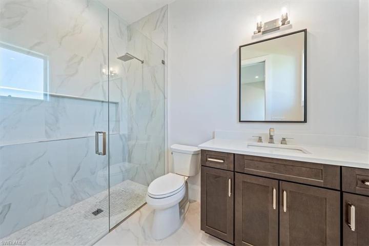 Bathroom 2 is light and spacious with so much storage and a window on the wall across from the shower.