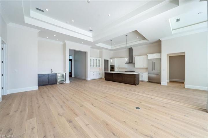The kitchen features white & wood tone shaker cabinetry, Pompeii Misterio quartz countertops, and Thermador appliances with natural gas cooking. The walk-in pantry just around the corner offers ample storage.