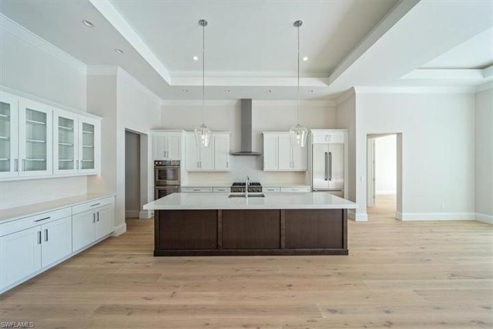 The kitchen features white & wood tone shaker cabinetry, Pompeii Misterio quartz countertops, and Thermador appliances with natural gas cooking. The walk-in pantry just around the corner offers ample storage.