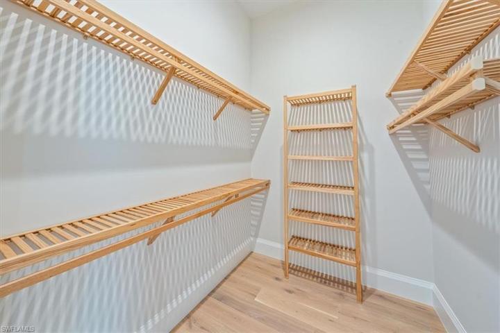 All closets in the home feature natural copewood shelving (vented in closets; solid in pantry). One of two primary closets shown.