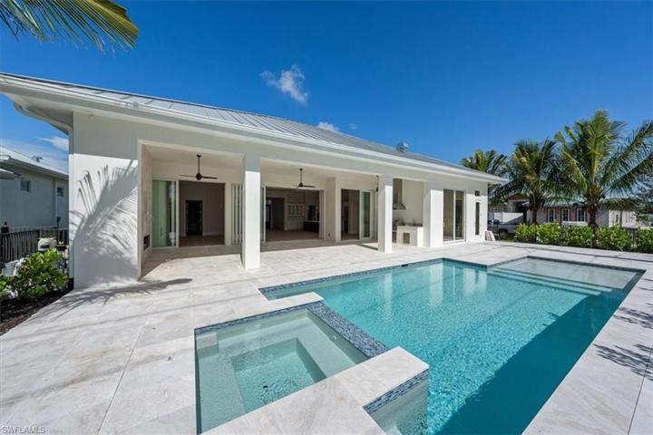 The pool deck features marble pavers, natural gas fireplace, outdoor kitchen, covered and uncovered areas, and pool with flush spa. Greenery has been planted along the rear and side property fence and will mature over the next several months. The openings have been pre-wired for optional roll-down bug and/or storm screens.