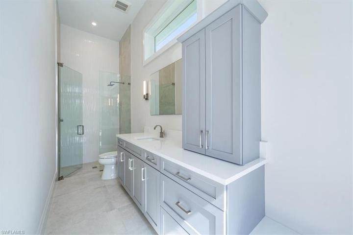 Bathroom 4 doubles as the pool bath and features linen storage and a quartz-top bench (towel hooks will be installed over the bench upon arrival).