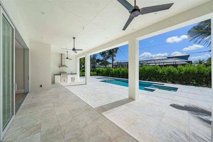 The pool deck features marble pavers, natural gas fireplace, outdoor kitchen, covered and uncovered areas, and pool with flush spa. Greenery has been planted along the rear and side property fence and will mature over the next several months. The openings have been pre-wired for optional roll-down bug and/or storm screens.
