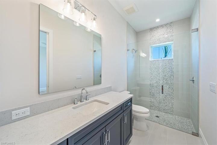Bathroom 3 features oversized linen closet, navy shaker cabinet, and natural light through the window in the shower.