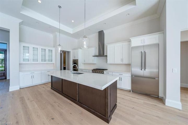 The kitchen features white & wood tone shaker cabinetry, Pompeii Misterio quartz countertops, and Thermador appliances with natural gas cooking. The walk-in pantry just around the corner offers ample storage.