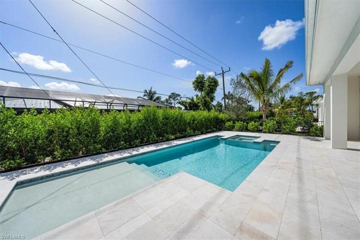 The pool deck features marble pavers, natural gas fireplace, outdoor kitchen, covered and uncovered areas, and pool with flush spa. Greenery has been planted along the rear and side property fence and will mature over the next several months. The openings have been pre-wired for optional roll-down bug and/or storm screens.