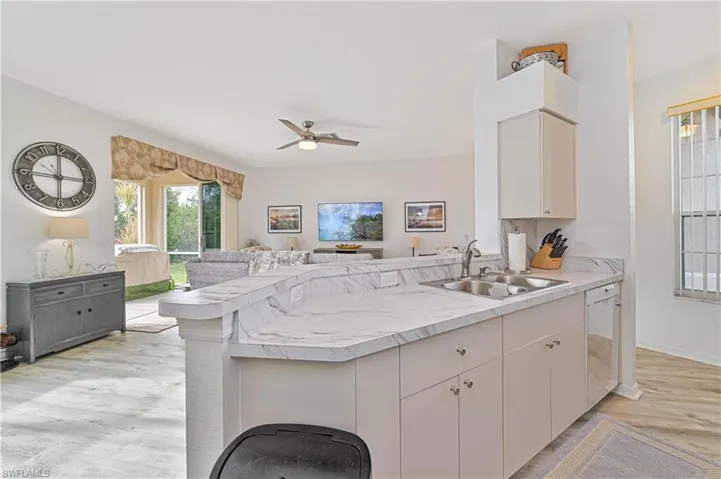 Kitchen with dishwasher, kitchen peninsula, and sink
