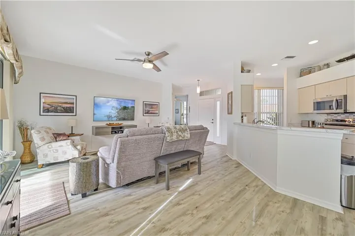 Living room with ceiling fan and light hardwood / wood-style flooring