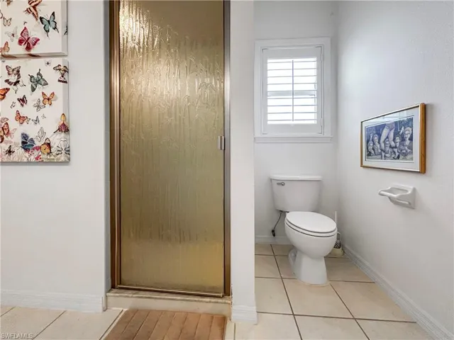 Bathroom featuring light tile patterned floors and a shower stall