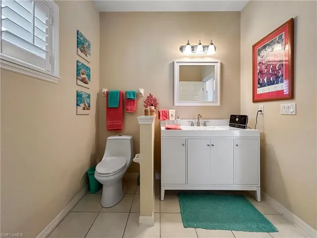 Half bathroom with vanity and light tile patterned floors