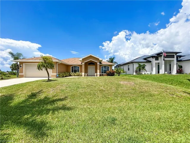View of front of house with driveway, a front lawn, a garage, and stucco siding