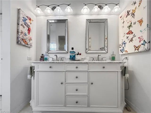 Bathroom with double vanity and a textured wall