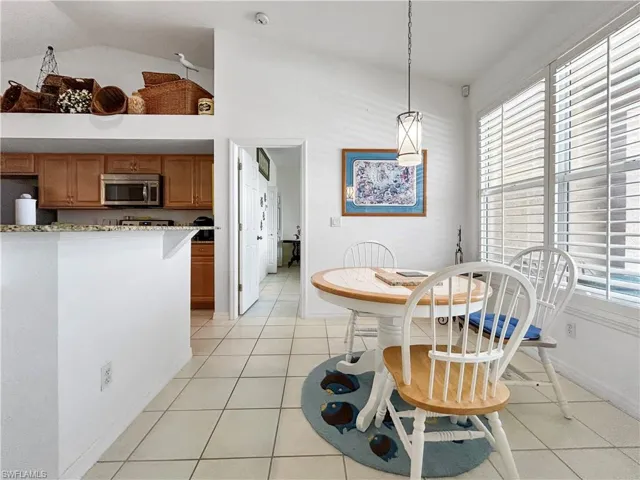 Dining room featuring light tile patterned floors and high vaulted ceiling