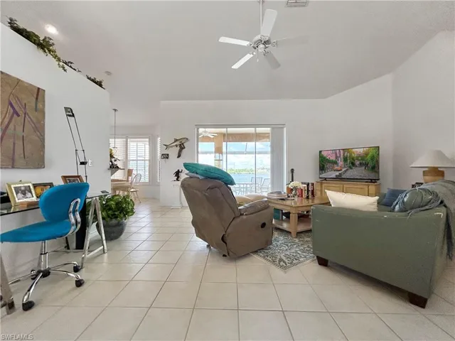 Living room featuring light tile patterned floors and ceiling fan