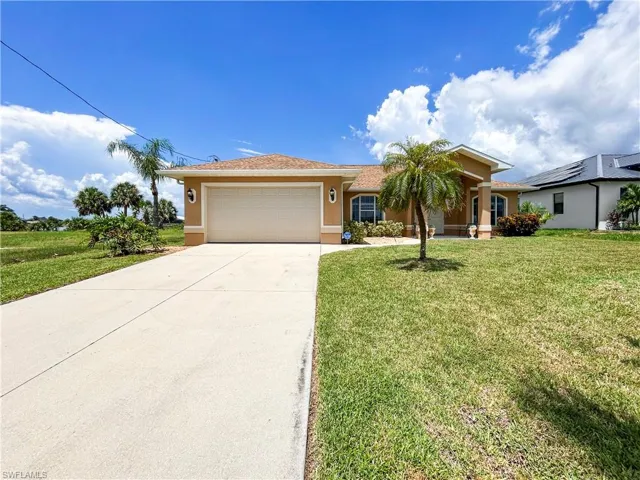 View of front facade featuring stucco siding, concrete driveway, a front lawn, and an attached garage