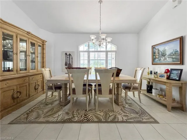 Dining space with light tile patterned floors and a chandelier
