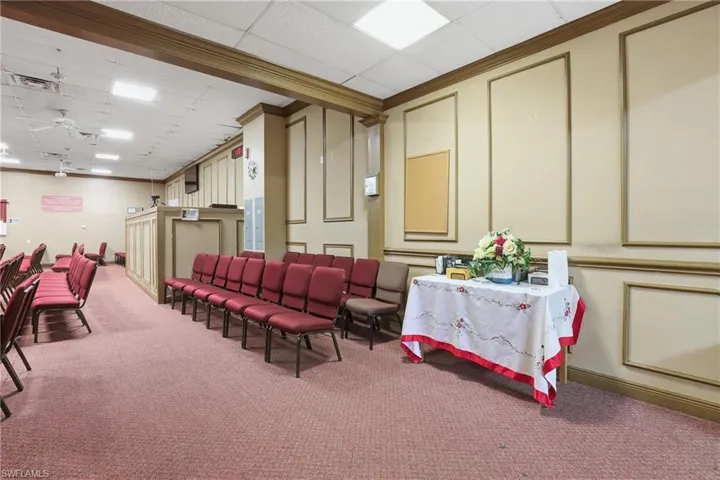 Misc room featuring a decorative wall, a drop ceiling, and crown molding