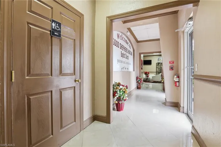 Hall featuring light tile patterned floors and baseboards