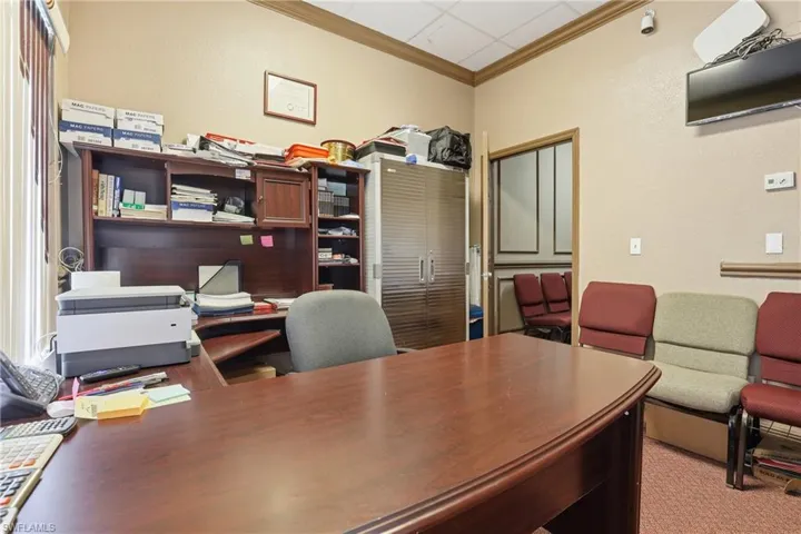 Office with ornamental molding and a textured wall