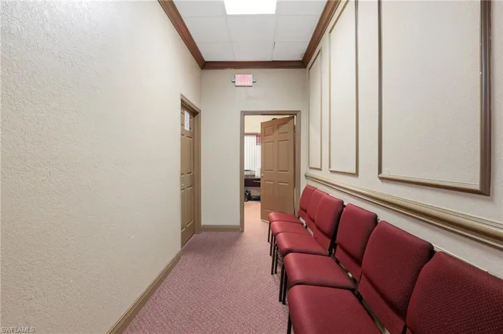 Hallway with carpet, ornamental molding, and a textured wall