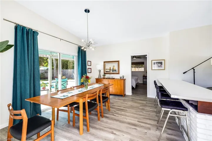 Dining room with ceiling fan with notable chandelier and light wood-type flooring
