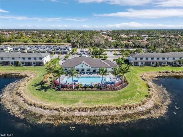 Drone / aerial view of a pool area and a nearby body of water
