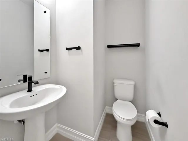 Bathroom with toilet and baseboards