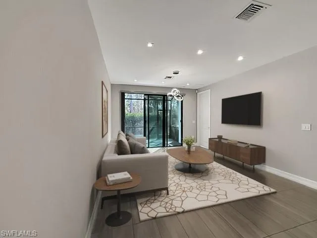 Living room featuring wood finished floors, recessed lighting, and a chandelier