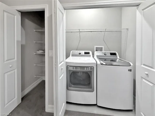 Washroom with separate washer and dryer and baseboards