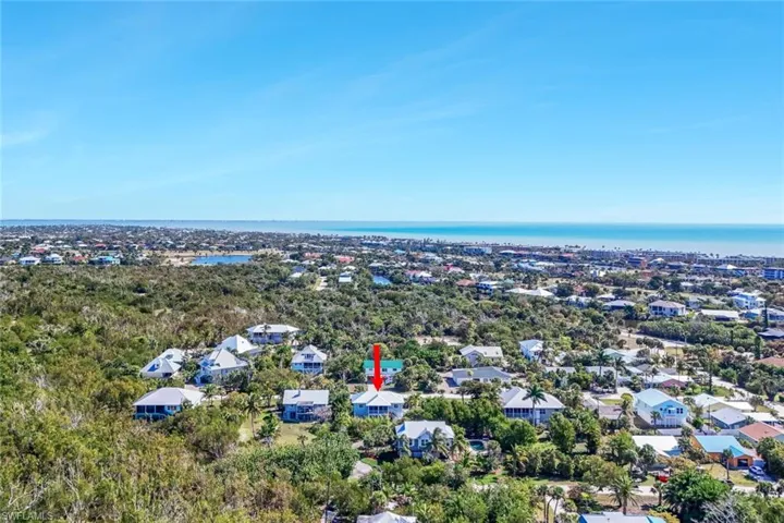 Aerial perspective of suburban area featuring a nearby body of water