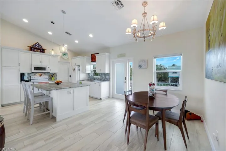 Dining area featuring lofted ceiling, suspended lighting, and light wood-style flooring