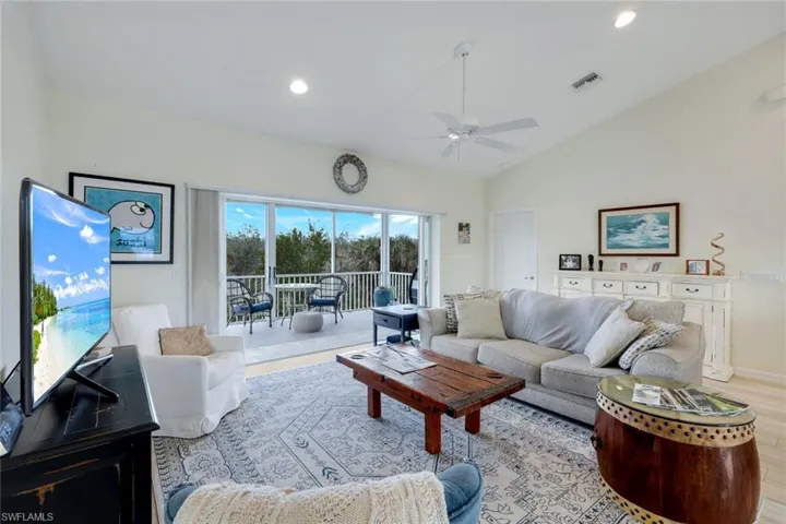 Living area with ceiling fan, wood finished floors, lofted ceiling, and recessed lighting