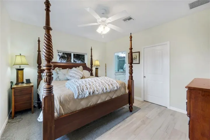 Bedroom featuring a ceiling fan, light wood-type flooring, and ensuite bathroom